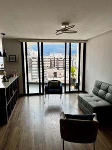 un salon avec un canapé et une chaise dans l'établissement Departamento la Carolina - Centro financiero y comercial Quito, à Quito