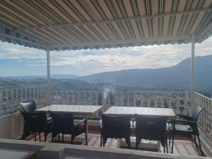 a table and chairs on a balcony with a view at Nouara Appart'Hotel in Chefchaouen +3 photos