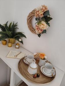 a table with a tray of tea cups and a wreath at Calin Apartment in Turin