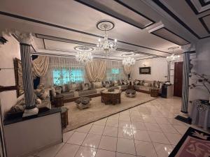 a large living room with a large couch and chandeliers at Tradicional & Luxury Apartment City Center & Beach & WiFi! in Tangier