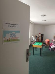 a room with a table and a sign on the wall at Všemina apartmán s terasou in Všemina