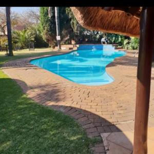 a swimming pool with blue water in a park at Aero Garden Ensuite in Johannesburg