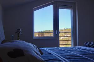 a bedroom with a bed and a large window at Apartmani Ana in Čapljina