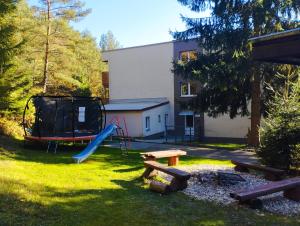 a yard with a playground and a slide at Všemina apartmán s terasou in Všemina