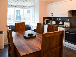 a kitchen with a wooden table in a room at Craven House in West Burton
