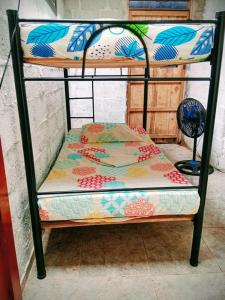 a bunk bed with a quilt on the bottom bunk at Hostal el Profe in Capurganá