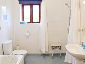 a white bathroom with a toilet and a sink at Hog Pits - 18961 in Tytherton Lucas +2 photos