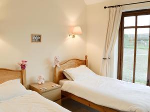 two beds in a room with a window at Hog Pits - 18961 in Tytherton Lucas
