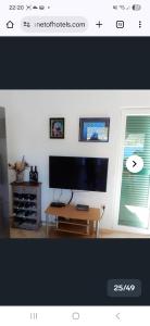 een woonkamer met een flatscreen-tv en een tafel bij Apartmani Aurelia in Veliki Drvenik