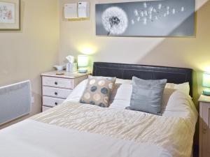 a bedroom with a bed with white sheets and pillows at Yew Tree Bothy in Old Brampton
