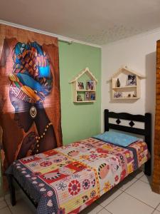 a bedroom with a bed with a painting on the wall at Casa no Sítio - Guaramiranga in Guaramiranga