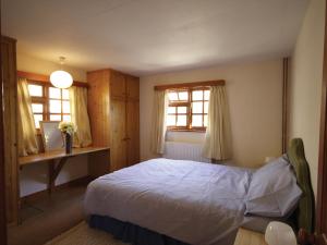 Sea PallingにあるMeadow Viewのベッドと机と2つの窓がある寝室