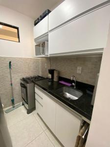 a kitchen with a sink and a stove at Joan Miro Flat - Ponta Negra in Natal