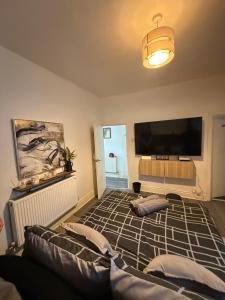 a living room with a flat screen tv and a couch at Home From Home in Liverpool