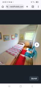 two beds in a room with a window at Apartmani Aurelia in Veliki Drvenik