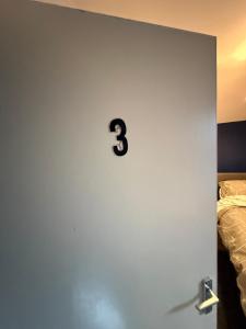 a door with a number three on it next to a bed at Home From Home in Liverpool +1 photo