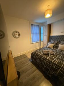 a bedroom with a bed and a clock on the wall at Home From Home in Liverpool
