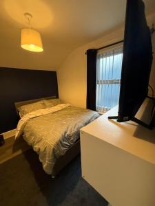 a bedroom with a bed and a television on a dresser at Home From Home in Liverpool