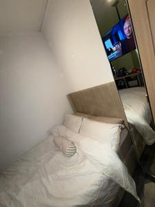 a white bed in a room with a mirror at Home From Home in Liverpool