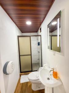 a bathroom with a toilet and a sink and a shower at Refugio Las Cortezas in Tapantí +32 photos