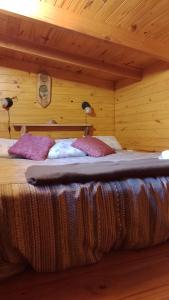 a bedroom with a bed in a wooden room at Hospedaje Las Gardenias in Lago Puelo