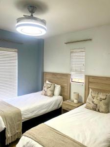 a bedroom with two beds and a light fixture at Entire Apartment in Eldoraigne, Centurion in Eldoraigne