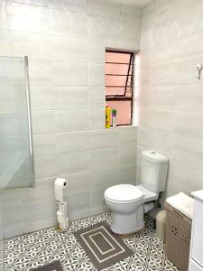 a bathroom with a toilet and a tile floor at Entire Apartment in Eldoraigne, Centurion in Eldoraigne +10 photos