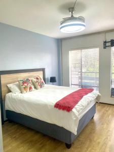 a bedroom with a large bed with a red blanket at Entire Apartment in Eldoraigne, Centurion in Eldoraigne