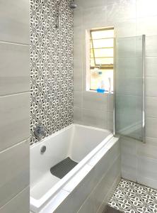 a white bath tub in a bathroom with a window at Entire Apartment in Eldoraigne, Centurion in Eldoraigne