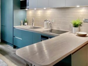 a kitchen with two sinks and blue cabinets at 2 Harney Peak in Portinscale