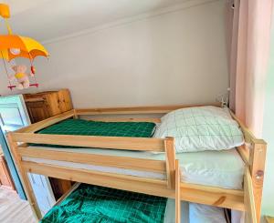 a bedroom with a bunk bed with green sheets at Oben im Selketal in Harzgerode