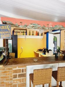 Zimmer mit einer Theke mit Stühlen und einer Küche in der Unterkunft Cabana CasaBah in São Sebastião