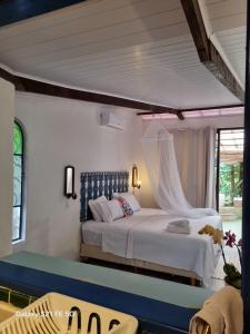 ein Schlafzimmer mit einem weißen Bett mit Himmelbett in der Unterkunft Cabana CasaBah in São Sebastião