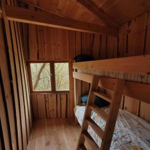 um quarto com um beliche e uma janela em Cabane octogone sauvage - Octogonia, Ardèche em La Rochette