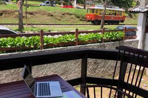 APART Deluxe Campos do Jordāo com lareira في كامبوس دو جورداو: كمبيوتر محمول موضوع على طاولة في شرفة مع قطار