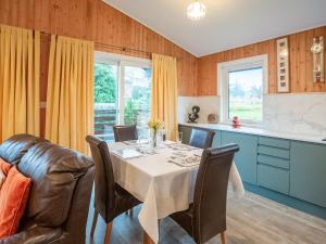 a kitchen and dining room with a table and a couch at Amber Nook in Tirril