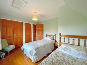 a bedroom with two beds and a chair at Fox Cottage - E4510 in Chipping Sodbury