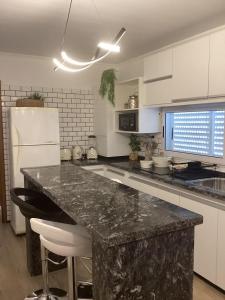 a kitchen with a marble counter top and a refrigerator at Departamento de lujo El Monte in San Nicolás de los Arroyos