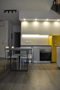 a dining room with a table and chairs and a kitchen at Giardino di Lei, appartamento giallo in Montegrotto Terme +16 photos