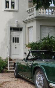 シャトノワにあるGîte avec parking, au calme, entre Colmar-Riquewihr et Obernai ,marchés de Noël, 3 chambres, avec terrasseの家の前に停車する緑車