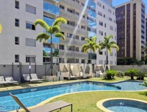 a swimming pool with chairs and a building at FLAT de luxo mobiliado na Savassi in Belo Horizonte +3 photos