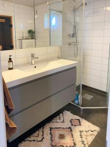 une salle de bain avec un lavabo et une douche avec un miroir dans l'établissement Family Cabin With View Over Fjord, Mountain, Wood, à Erfjord