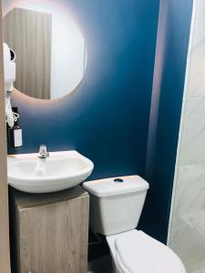 a bathroom with a white toilet and a sink at HAB 108- Hermosa, cómoda y moderna in Medellín