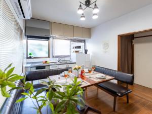 a kitchen and dining room with a table and chairs at 海街ゲストハウス in Takamatsu