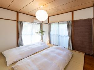Postel nebo postele na pokoji v ubytování 海街ゲストハウス