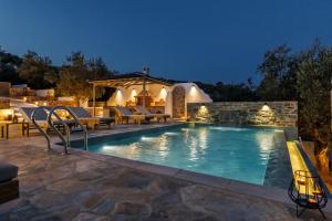 a swimming pool in a backyard at night at Luxury VILLA RAFAEL in Skopelos Town