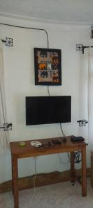 a television on a wall with a wooden table at Victoria Stay in Jinja