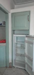 an empty refrigerator with its door open in a kitchen at Victoria Stay in Jinja