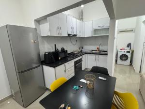 a kitchen with a table and a refrigerator at Apartamento 1 Quarto - Baixa de Luanda in Luanda +9 photos