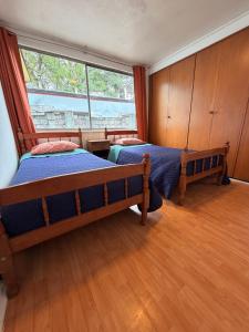 a bedroom with two beds and a large window at Casa Cypresses in Temuco